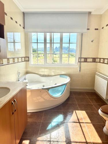 a large bathroom with a tub and a window at Balcón da Ría in Cambados