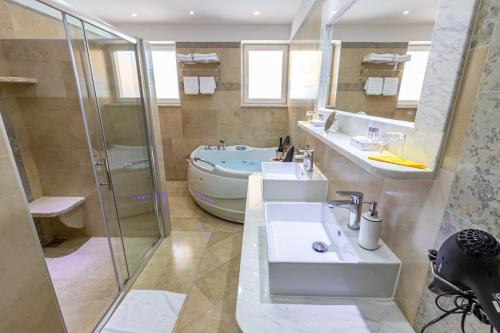 a bathroom with a sink and a shower and a tub at Organic Gardens Villa in Crikvenica
