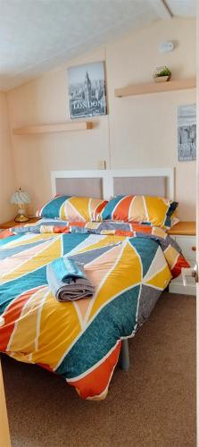 a bedroom with two beds with colorful sheets at Stay 6 - Pool - Parking - BeachSide - Pet Friendly in Trimingham