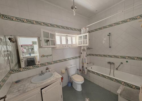 a bathroom with a sink and a toilet and a tub at Antique seaside appartement in Mahdia