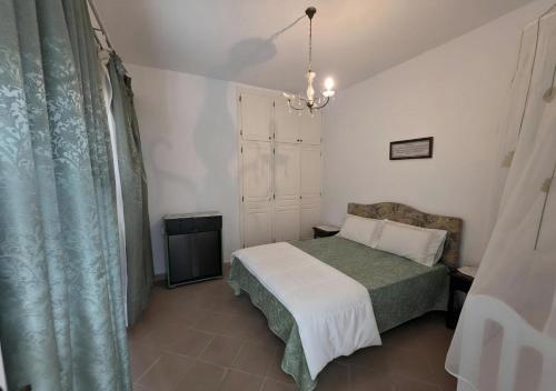 a bedroom with a bed and a chandelier at Antique seaside appartement in Mahdia