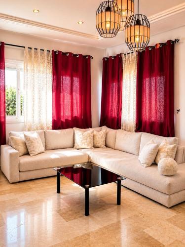 a living room with a couch and red curtains at Modern Apartment - Center of Fez in Fez