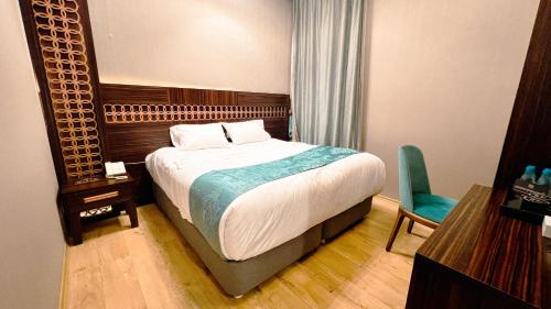 a bedroom with a bed and a desk and a chair at فندق أوركيد مكة in Mecca