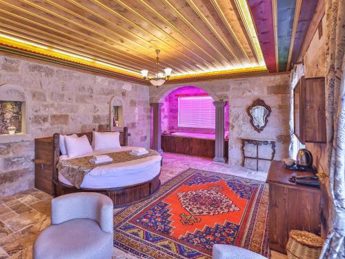 a bedroom with a bed in a room with pink lighting at Noble Crown Stone House Cappadocia in Uçhisar