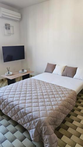 a bedroom with a large bed and a desk at La casa de valras in Valras-Plage