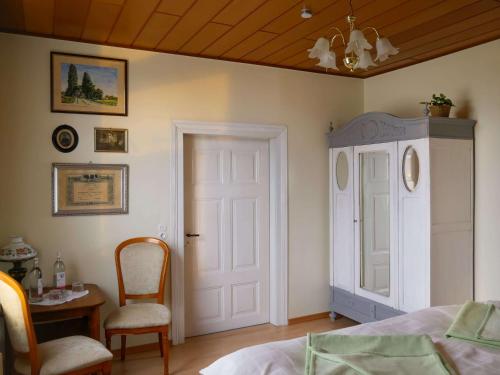 a bedroom with a bed and a table and a chair at Die Gute Stube in Dobritz