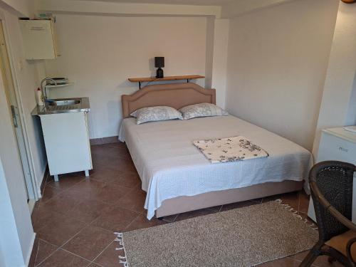 a small bedroom with a bed and a table at Apartman Pavle 2 in Virpazar