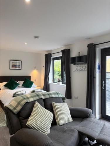 a bedroom with a bed and a couch at Hillview Cabin in Oban