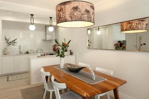 a kitchen and dining room with a wooden table and chairs at Luxurious Bohemian Residence with Pool in Tivat