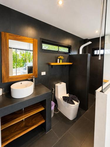 a bathroom with a sink and a toilet at Villa Ravenala in Chaweng in Ban Ko Khwan