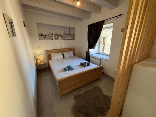 a small bedroom with a bed and a window at Escapade en Auvergne - centre historique - 3 personnes in Olliergues