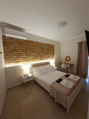 a bedroom with a large bed and a brick wall at Elia Studios 2 in Nydri