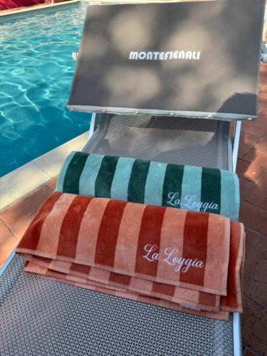 a towel sitting on a chair next to a swimming pool at La Loggia di Montefienali in Gaiole in Chianti