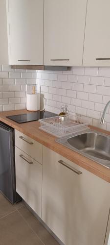 a kitchen with white cabinets and a sink at Elia Studios 2 in Nydri