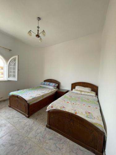 a bedroom with two beds and a window at Dina Mansour's vacation home 54 A upper in Dawwār ‘Abd Allāh