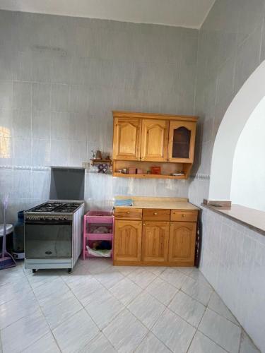 a kitchen with wooden cabinets and a stove top oven at Dina Mansour's vacation home 54 A upper in Dawwār ‘Abd Allāh
