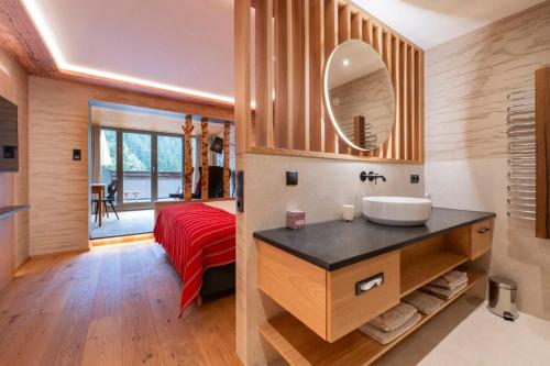 a bathroom with a sink and a red bed at Boutiquehotel Grandau in Sankt Gallenkirch