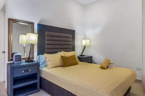 a bedroom with a bed and two lamps and a mirror at Dog-Friendly Beach Haven with Heated Pool, Hot Tub, Kitchenette, Patio, AC in Rosarito