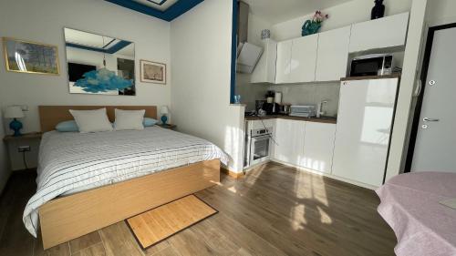 a small bedroom with a bed and a kitchen at In Blu Santo Ospedale in Padova