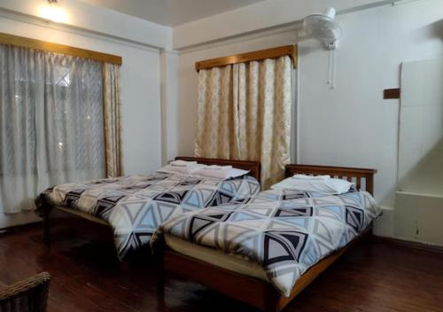 two beds sitting next to each other in a bedroom at Crossroad in Shillong