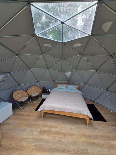 a bedroom with a bed in a dome tent at Spranču Glempings in Bernāti