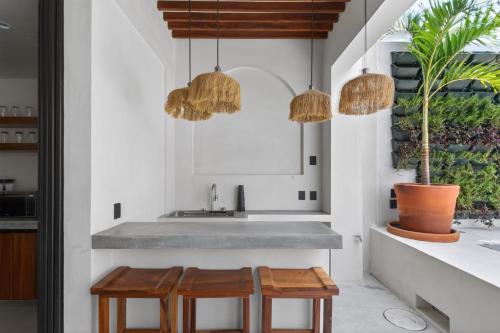 a kitchen with two stools and two pendant lights at La Barra Resorts Luxury Villas in Paso Hondo