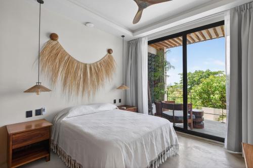 a bedroom with a bed and a large sliding glass door at La Barra Resorts Luxury Villas in Paso Hondo