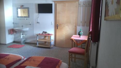 ツェル・アム・ツィラーにあるFerienwohnungen Eggerのベッド2台、バスルーム(シンク付)が備わる客室です。