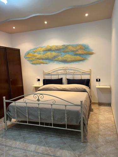 a bedroom with a bed with a painting on the wall at Antica Casa Cavaliere in Tramonti