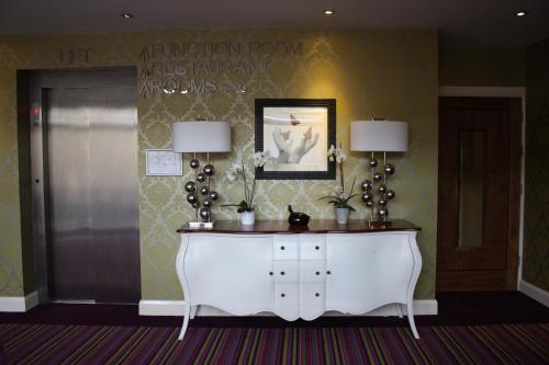 a room with a table, a mirror and a vase of flowers at The Talbot Hotel in Belmullet