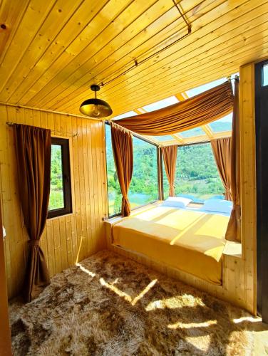 a bedroom with a bed in a room with a window at Glass House Merisi 2 in Merisi