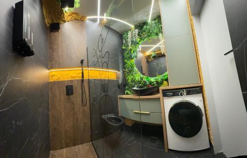 a bathroom with a mirror and a washing machine at Mabelle Gold Stay in Baia Mare