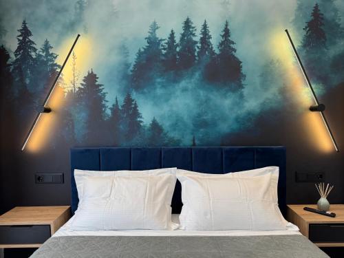 a bedroom with a bed with a forest mural at Mabelle Gold Stay in Baia Mare