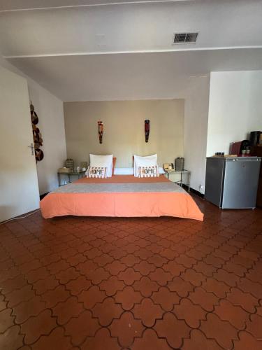 a bedroom with a large bed with an orange spread at Le Rêve Ocre in Toulon
