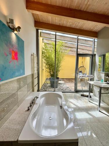 a large bath tub in a room with a table at PaderCityLoft- lichtdurchflutet und privat mit Kamin-Dachterrasse-Sauna-Außendusche im Atrium in Paderborn
