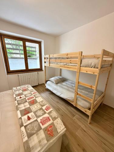 a bedroom with two bunk beds and a window at Dolce Vetta Valmalenco in Chiesa in Valmalenco