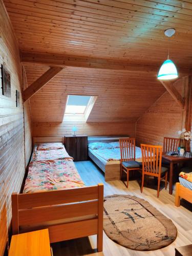a room with a bed and a table and chairs at Dom Rybaka Bobolin in Bobolin