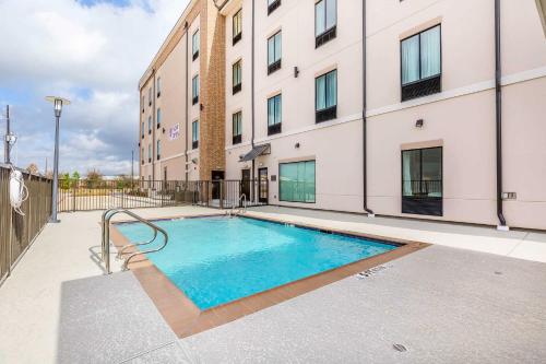 a swimming pool in front of a building at Comfort Suites Near Sam Houston Race Park in Houston