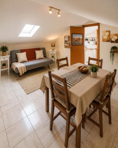 a living room with a table and a couch at Appartamentino Mansardato in Pedara