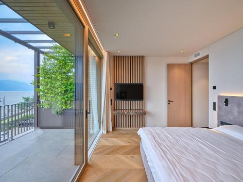 a bedroom with a large bed and a balcony at Luxury Apartments La Baia - Penthouse in Torri del Benaco