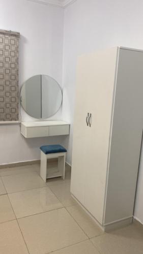 a white bathroom with a mirror and a stool at شوران الفاخرة 2 in Medina