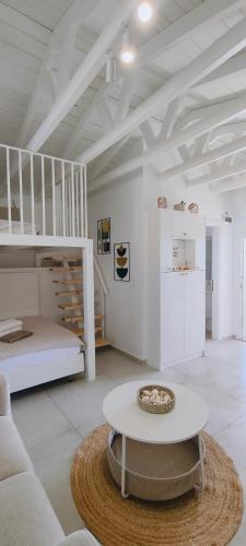 a white living room with a table and a bed at Lighthouse in Kallirákhi