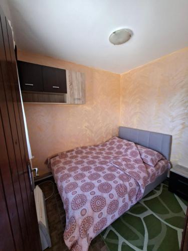a small bedroom with a bed with a pink blanket at Ribnica in Ribnica