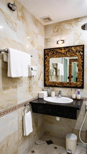 a bathroom with a sink and a mirror at Hotel HOÀNG THANH THỦY BÀ RỊA - VŨNG TÀU in Ho Coc