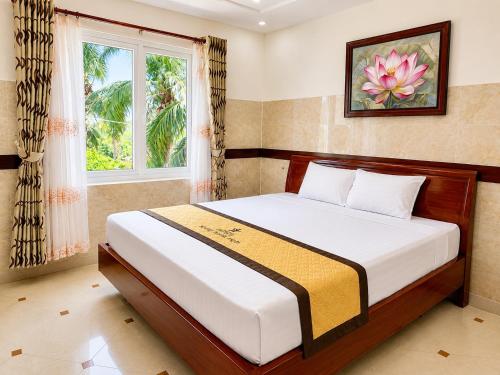 a bedroom with a large bed with a window at Hotel HOÀNG THANH THỦY BÀ RỊA - VŨNG TÀU in Ho Coc