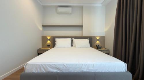 a bedroom with a large white bed with two pillows at Art Hotel Vlora in Vlorë