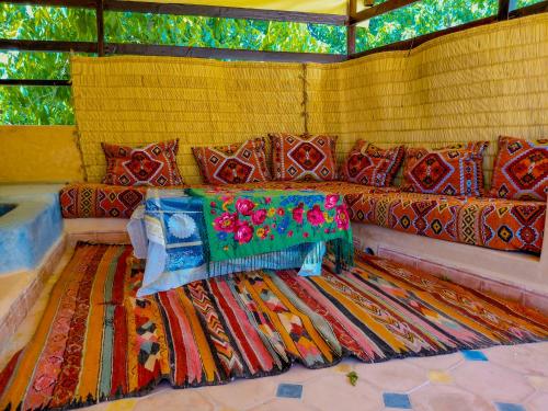 a couch with colorful pillows on it with a rug at Adrar N Darn Guesthouse in Taroudant