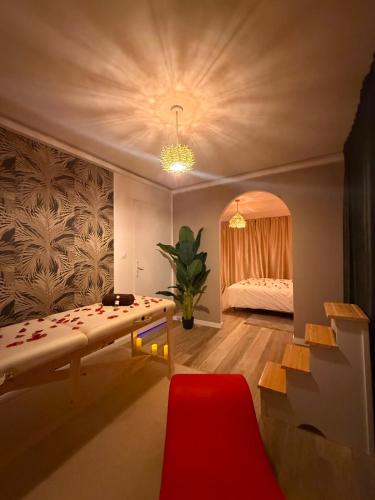 a living room with a bed and a red chair at Villa Romance Intime Prestige -Jacuzzi Privatif, , Table a massage , Fauteuil tantra, Balançoire romantique in Vienne