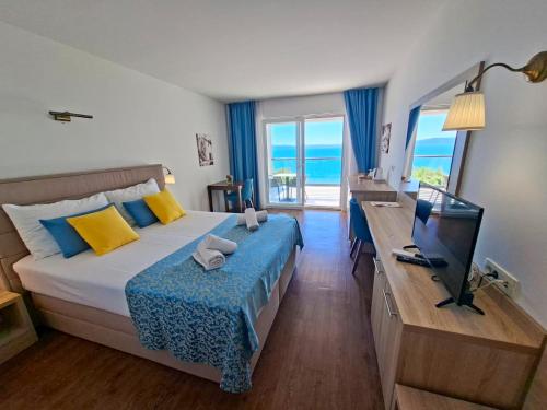 a bedroom with a bed and a television and the ocean at Villa Cascada in Podgora