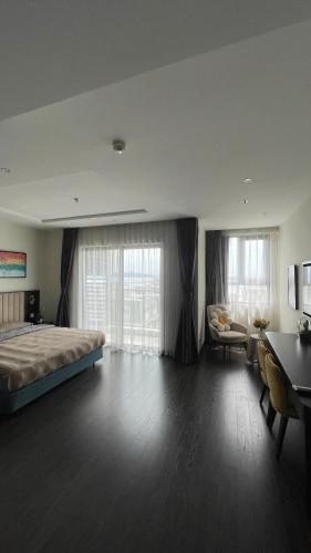 a large bedroom with a bed and a desk at Studio Sapphire Hạ Long View Biển in Ha Long